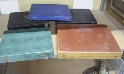 quatre valises posées sur une table, avec une horloge en arrière-plan