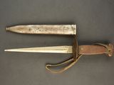 an old knife is laying on a table next to a leather sheath