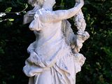 a statue of a woman holding a bunch of grapes