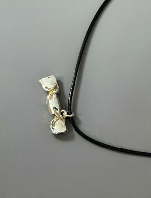 a white bone on a black cord on a gray surface