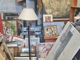 une photo d'une pièce remplie de tableaux et d'une lampe