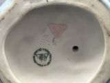 a white porcelain vase with a pink triangle on it