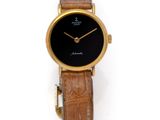 an image of a gold wrist watch with a black dial