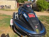 un jet-ski noir et bleu sur une remorque, dans l'herbe