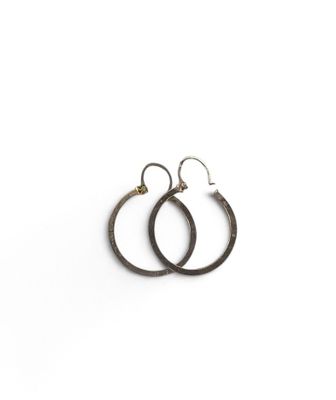 une paire de boucles d'oreilles créoles noires sur fond blanc