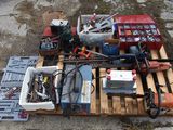 une palette remplie d'outils et des outils posés par terre