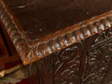 a wooden table with a brown top and a red rug on the floor