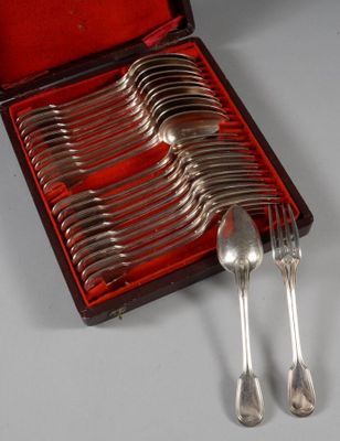 des couverts dans un coffret rouge posé sur une table où se trouvent d'autres couverts