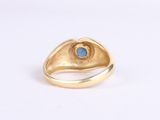 a close up of a gold ring with a blue stone in it