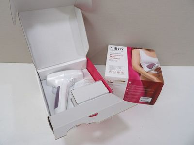 une boîte blanche munie d'une poignée rose et contenant une paire de ciseaux