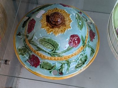 a blue bowl with a sunflower on it sitting on a tiled floor