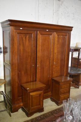 une armoire en bois, avec deux chaises et une table devant