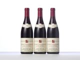 three bottles of wine are lined up on a table