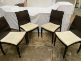 trois chaises de salle à manger noires et blanches disposées devant une table blanche