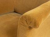 mustard colored chair with gold fringes on the legs and arms
