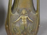 a bronze vase with a little girl on it
