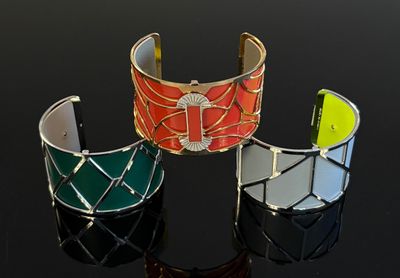 trois bracelets de couleur différente posés sur un fond noir