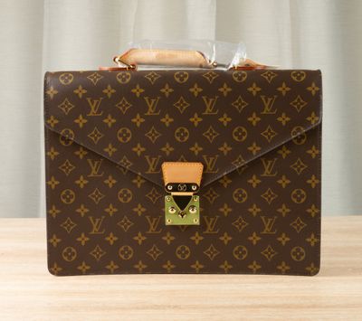 a brown briefcase sitting on top of a wooden table