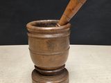 an old mortar with a wooden stick in it on top of a table