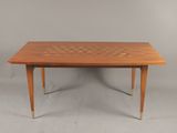 une table en bois dont le plateau est à carreaux