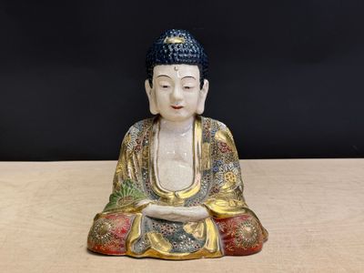 une petite statue de Bouddha assis sur une table