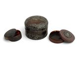 a small round box with a lid and two smaller ones