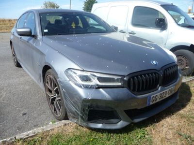 une BMW argentée garée sur un parking à côté d'une camionnette blanche
