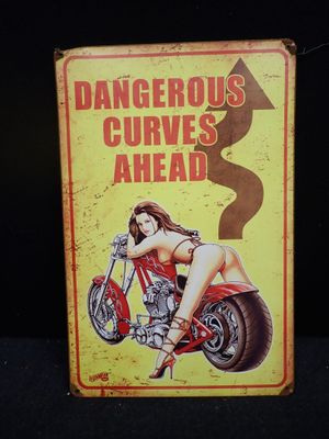 un panneau indiquant « virages dangereux » avec une femme à moto