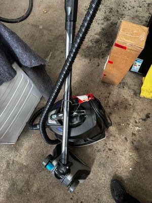 un aspirateur posé par terre à côté d'un sac