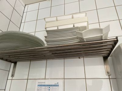 une pile d'assiettes et de bols posée sur une étagère dans une salle de bains