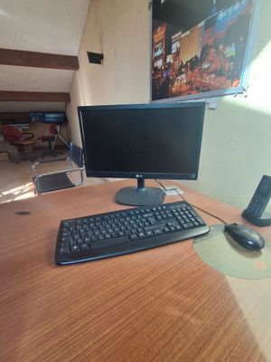 une photo d'un bureau d'ordinateur avec un clavier et un écran