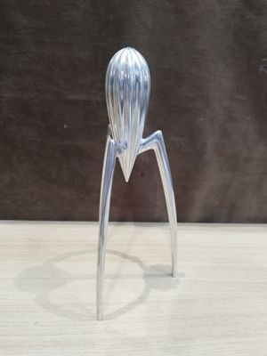 a silver metal sculpture of a person on a table