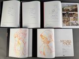 several open books on a table with a drawing of a man and a woman