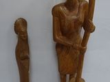 two wooden figurines sitting next to each other on a table