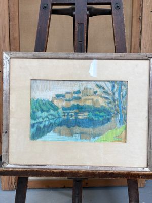 peinture posée sur un chevalet, avec un tableau représentant un paysage en arrière-plan