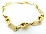 gros plan d'un bracelet en chaîne en or sur une surface blanche