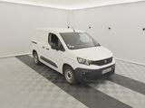 La camionnette blanche est garée dans une pièce propre dont le sol est recouvert d'un carrelage à damier noir et blanc.