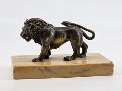 an image of a bronze statue of a lion on a marble base