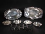 silverplated dishes and trays on a black background
