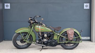 a green motorcycle parked in front of a garage door