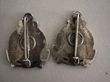 two pieces of silver are shown on a white surface