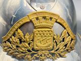 a silver helmet with a gold crest on it