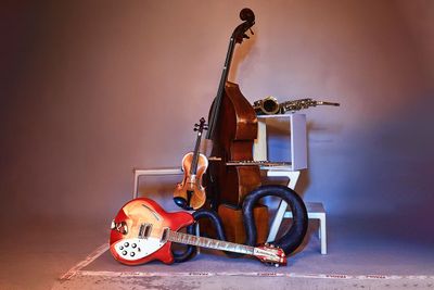 une guitare, une basse et un saxophone posés sur une table
