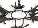 a cross made out of metal with flowers and leaves on it