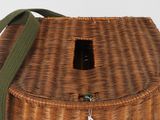 a wicker basket with a green strap on it