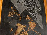 a picture of a black and gold table with a bird on it