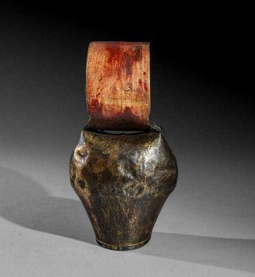 un vieux vase avec un couvercle en bois posé sur une table