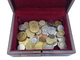 a box full of coins sitting on a white surface