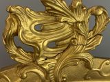 a mirror with a gold decoration on it in a room