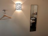 an image of a bedroom with a mirror and a coat rack